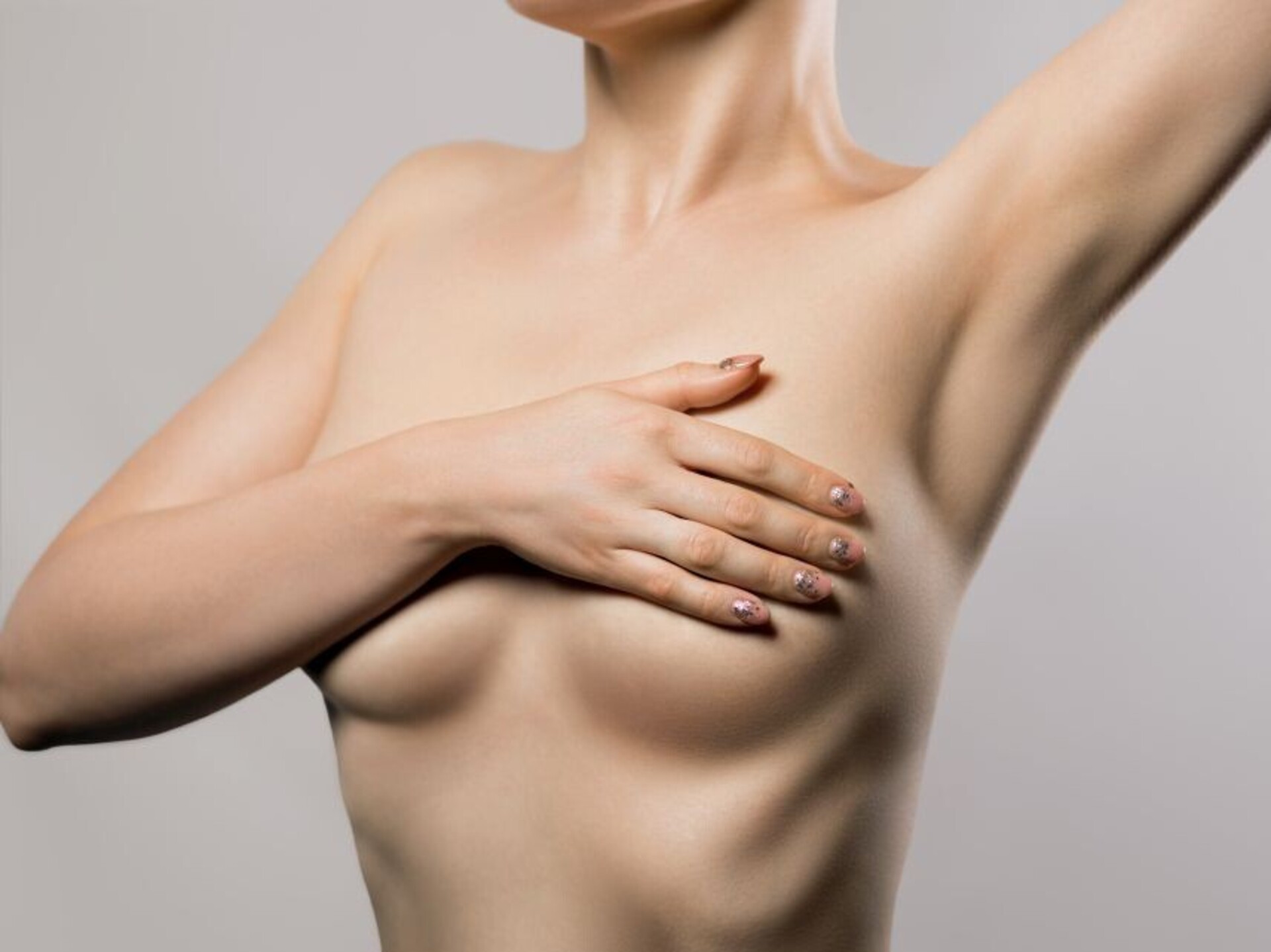 Kapselfibrose: Frau bedeckt Brüste mit Händen